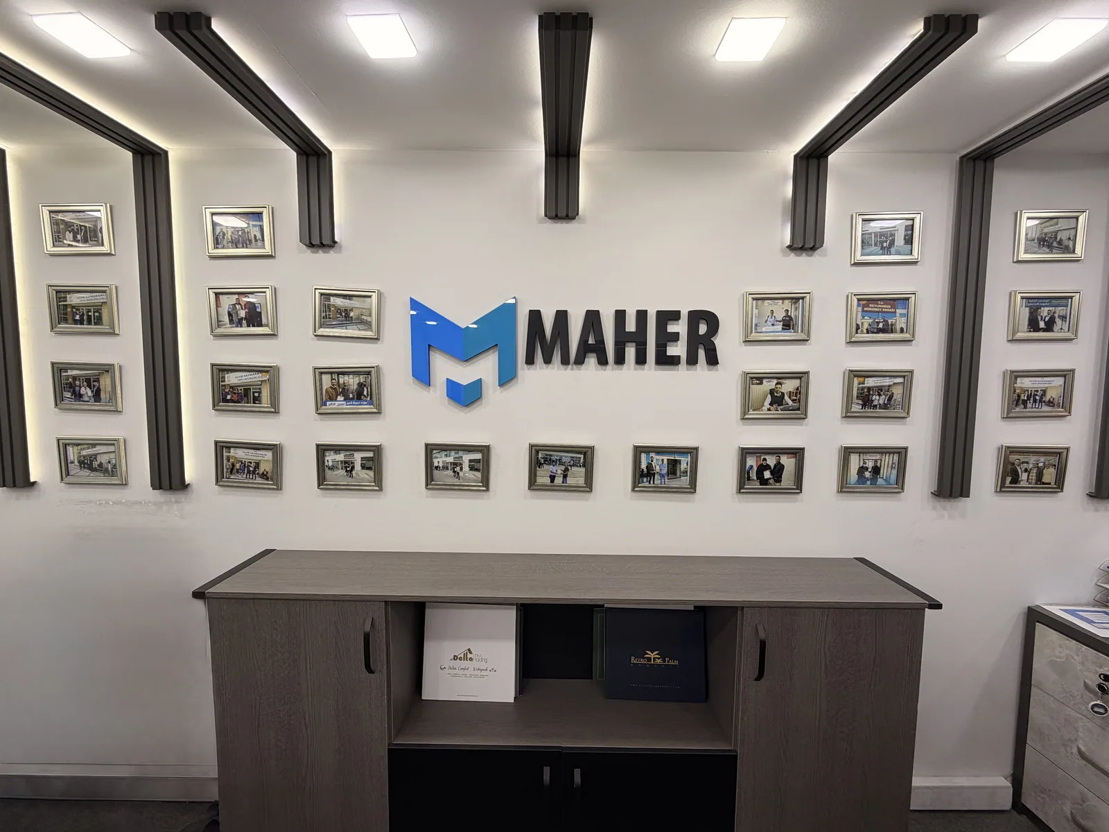 The Maher logo and photo wall behind the reception counter